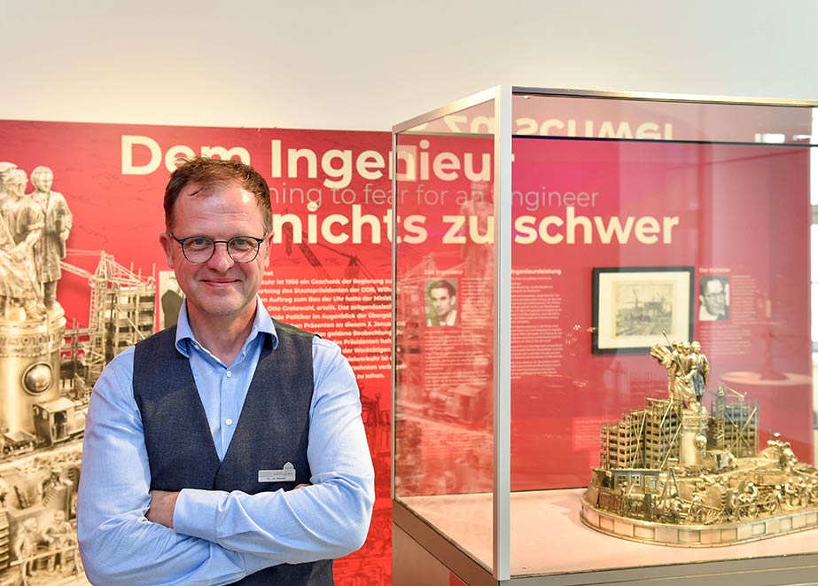 In der neuen Foyer-Ausstellung im Glashütter Uhrenmuseum dreht sich alles um Ingenieurinnen und Ingenieure an der Glashütter Lehranstalt. Das Foto zeigt Dr. Ulf Molzahn, Leiter Uhrenmuseum, neben der Kunstuhr von Wilhelm Pieck.