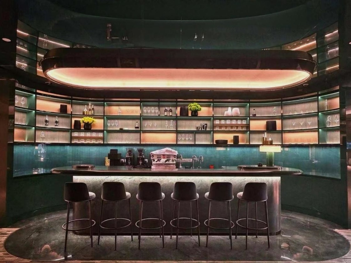 Bar mit Hockern und beleuchteten Regalen in der Rolex-Boutique von Bucherer in Hongkong